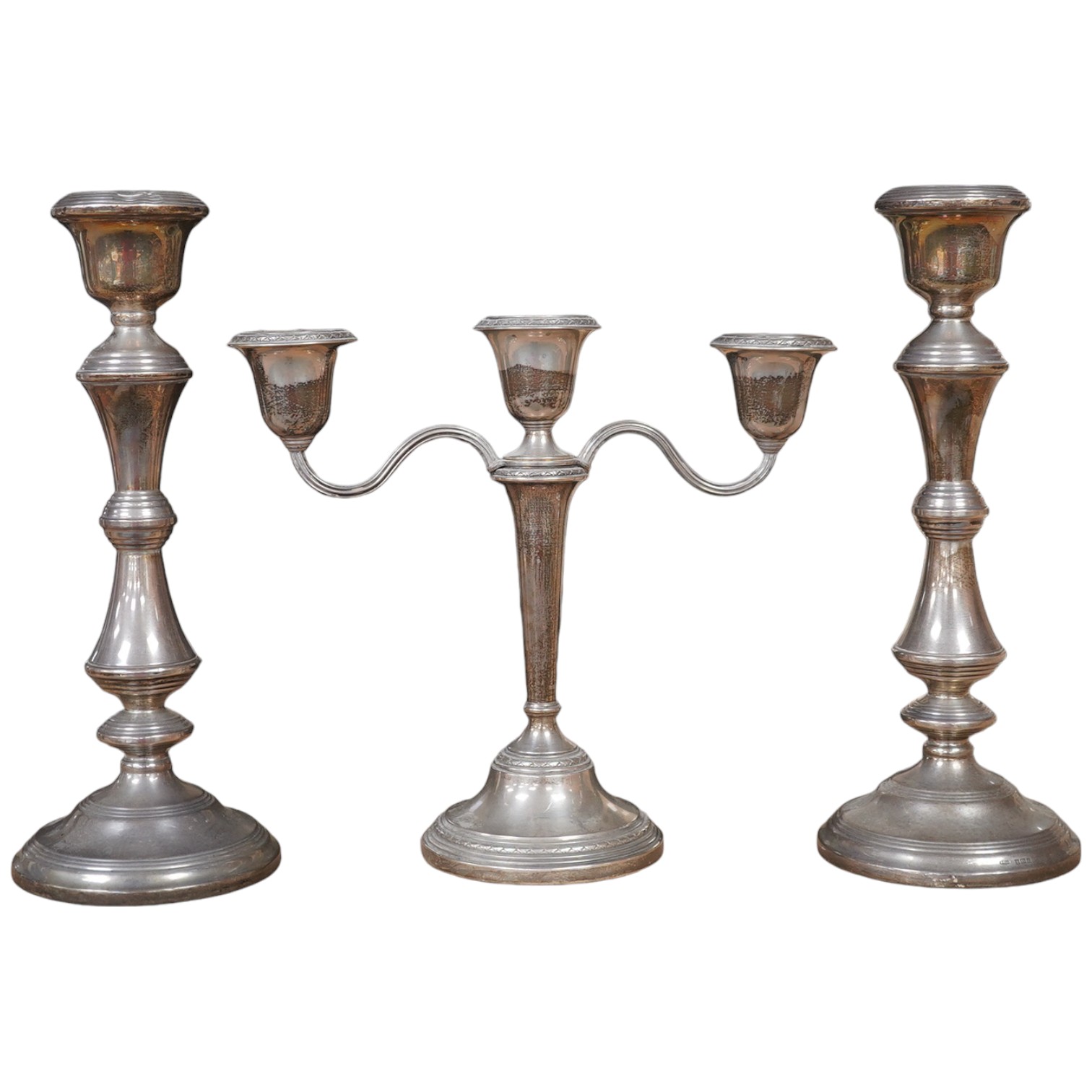 A pair of Elizabeth II silver candlesticks, Broadway & Co, Birmingham, 1960, 25.7cm, weighted, together with a similar silver three light candelabrum, by Adie Bros, weighted. Condition - poor to fair